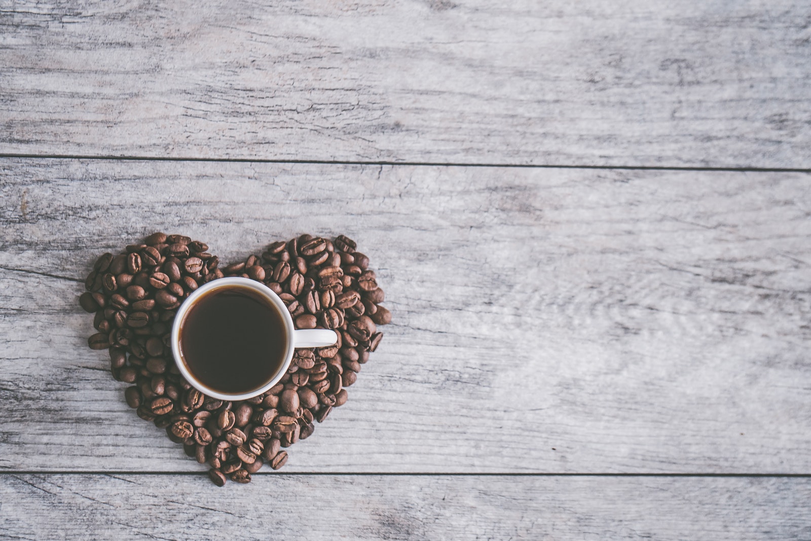 White Ceramic Mug on Brown Coffee Beans