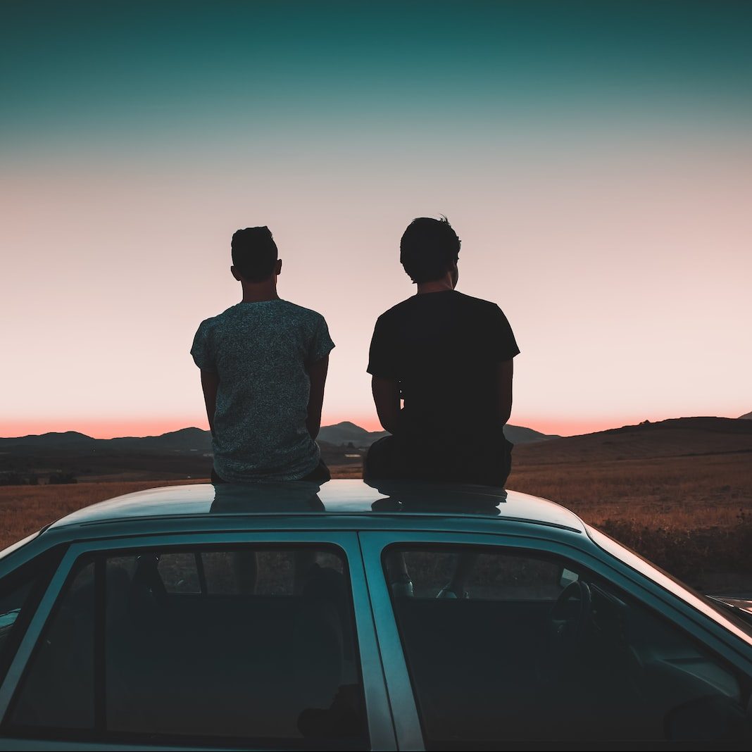 two men sitting on vehicle