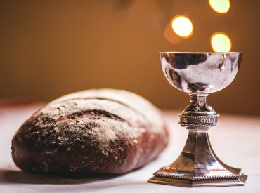 gray footed cup beside baguette bread