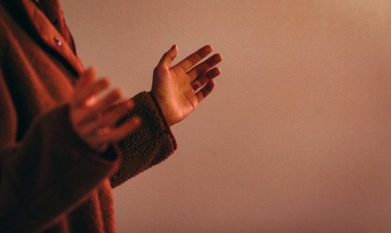 person in red sweater wearing silver ring