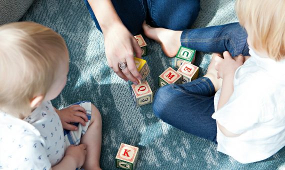 two toddler playing letter cubes