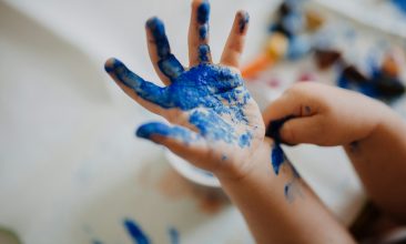 person with blue paint on hand