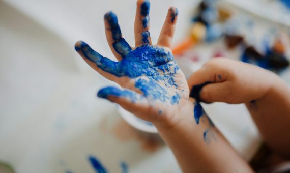 person with blue paint on hand