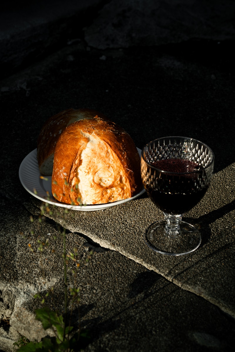Bread and wine on a textured stone surface.