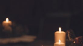 white pillar candle on brown wooden table