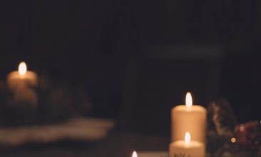 white pillar candle on brown wooden table