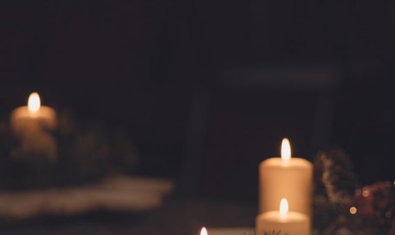 white pillar candle on brown wooden table