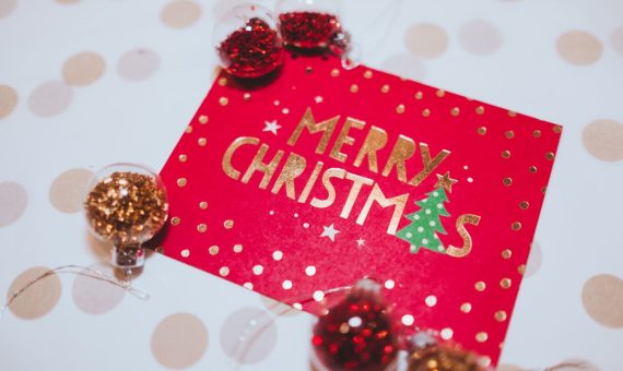 A vibrant red Merry Christmas card surrounded by festive glitter ornaments, perfect for holiday celebrations.