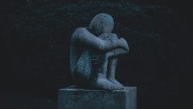 man hugging his knee statue