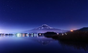 a night view of a lake with a mountain in the background