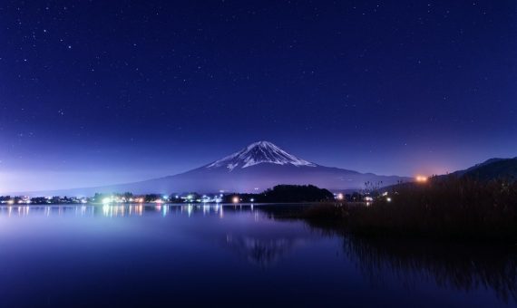 a night view of a lake with a mountain in the background