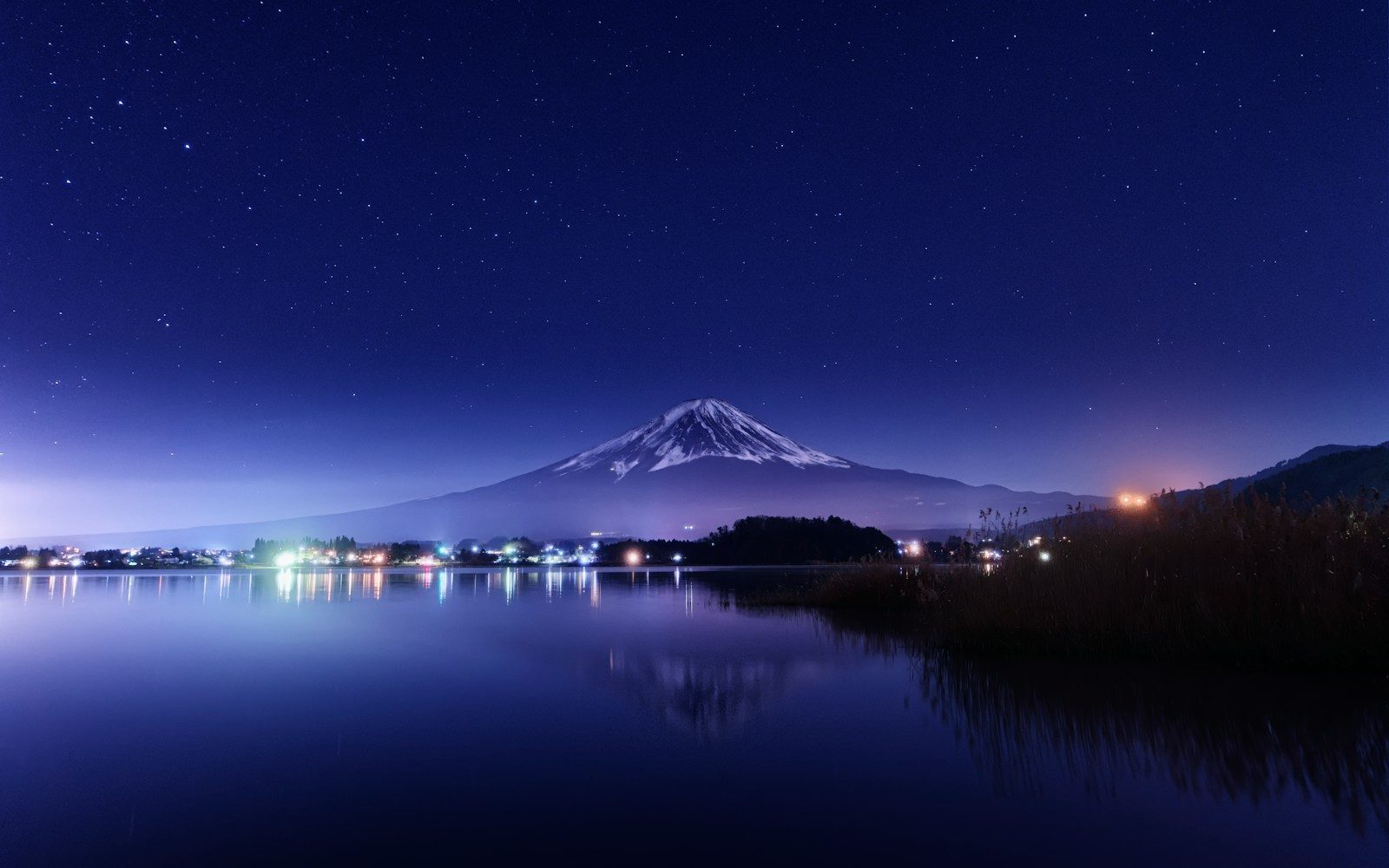a night view of a lake with a mountain in the background