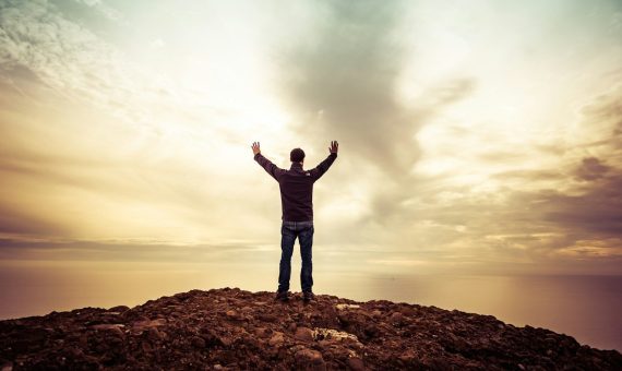 man standing under orange sky