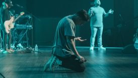 a man sitting on the floor in front of a microphone