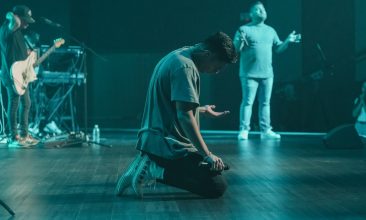 a man sitting on the floor in front of a microphone