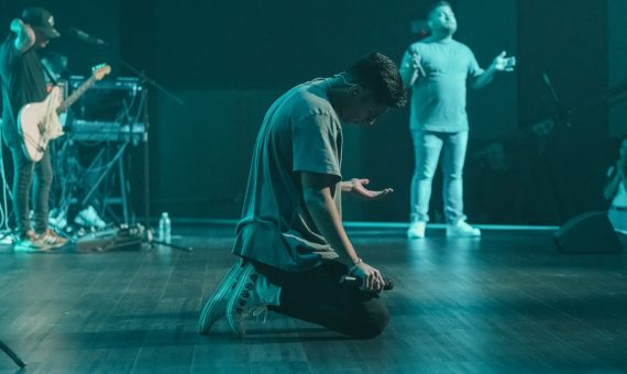 a man sitting on the floor in front of a microphone